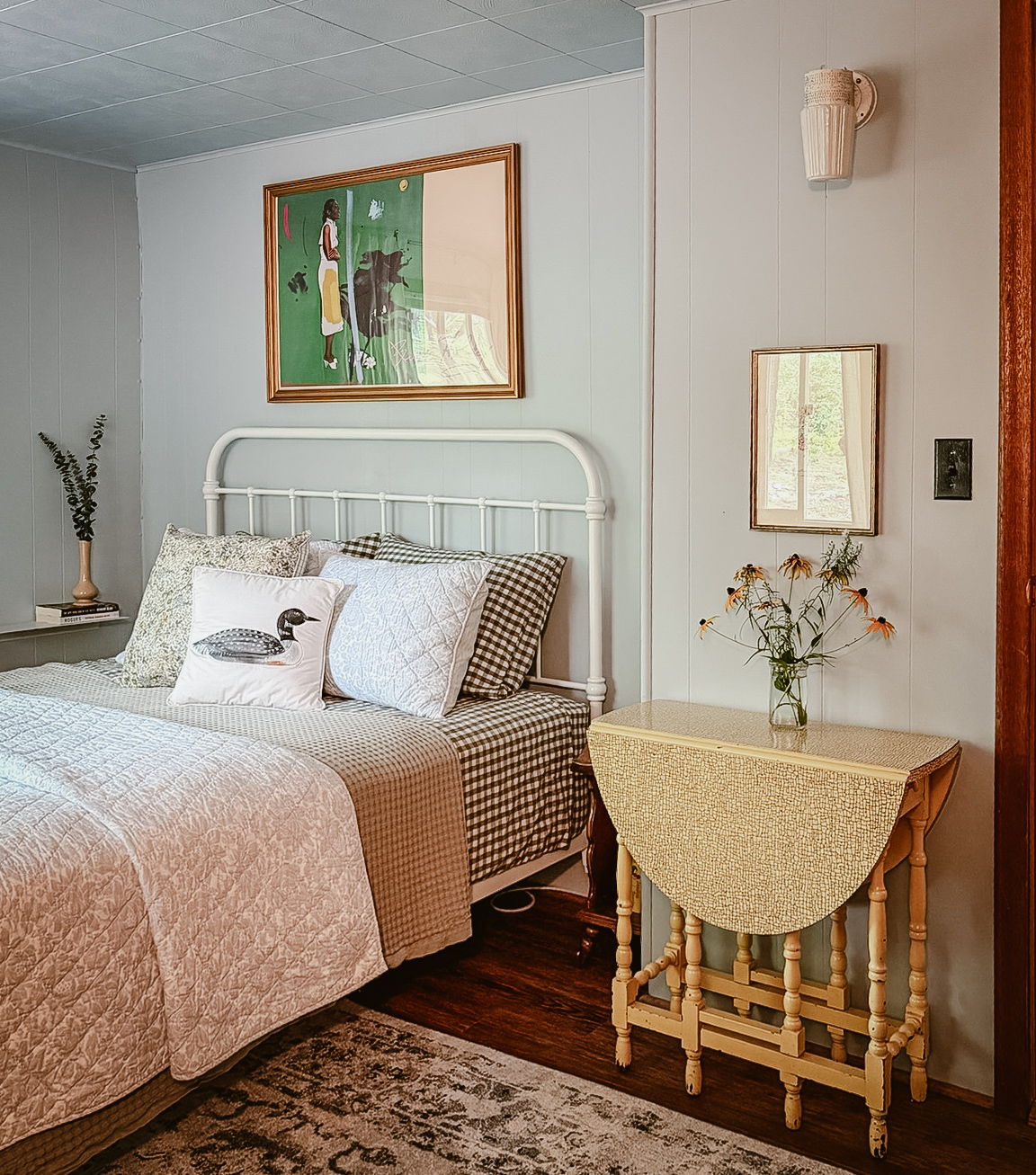 The second bedroom with a loon pillow and a vintage bedside table