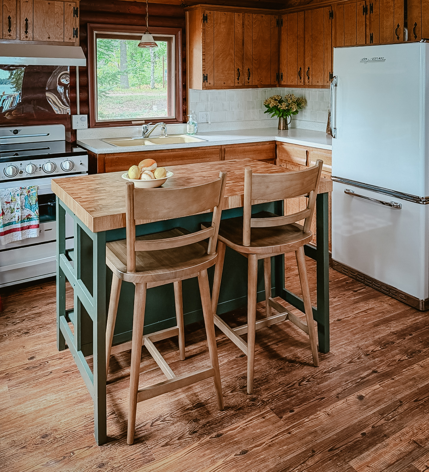 The cabin kitchen with wood cabinets and pine walls
