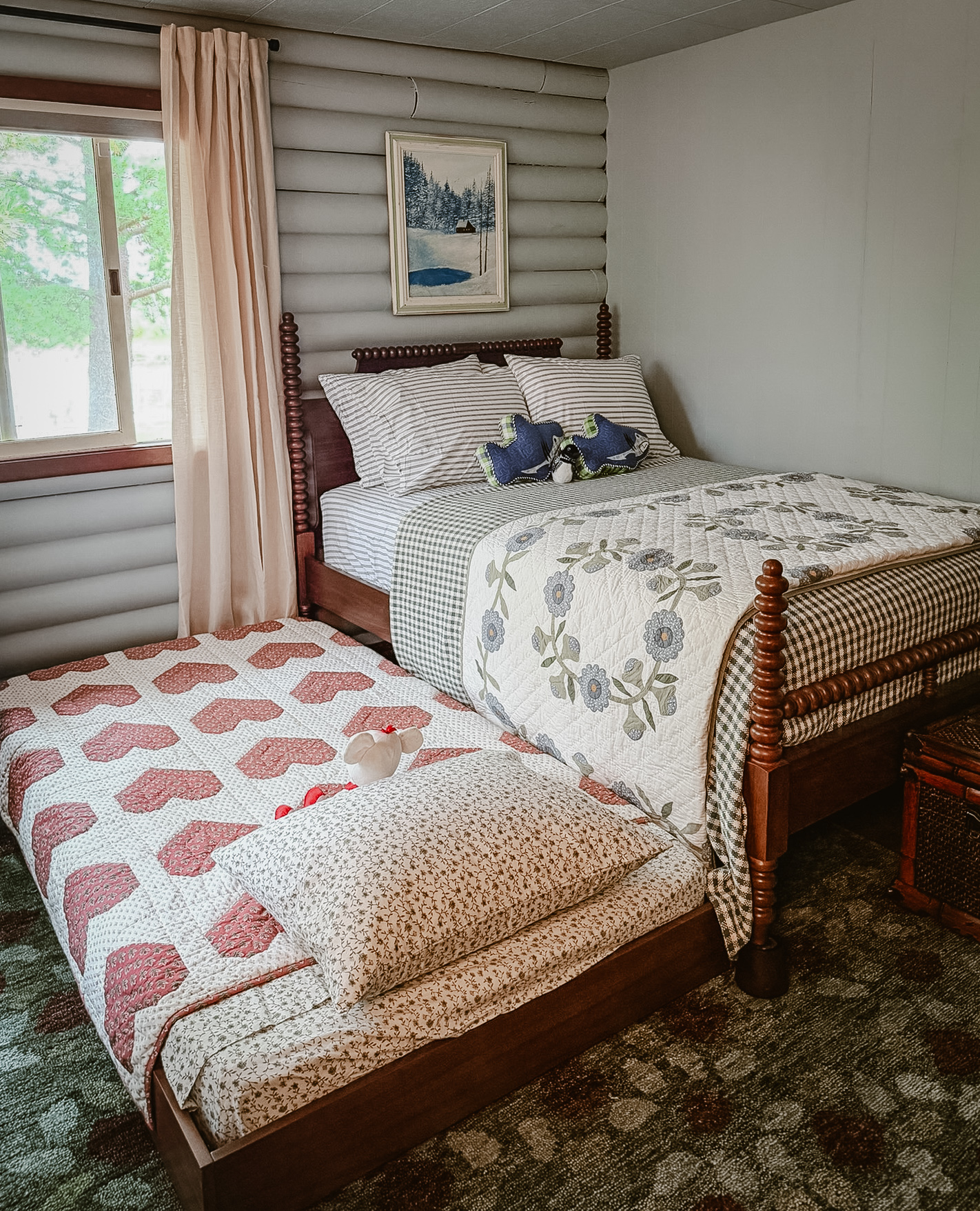 The first bedroom with log walls and quilted bedding