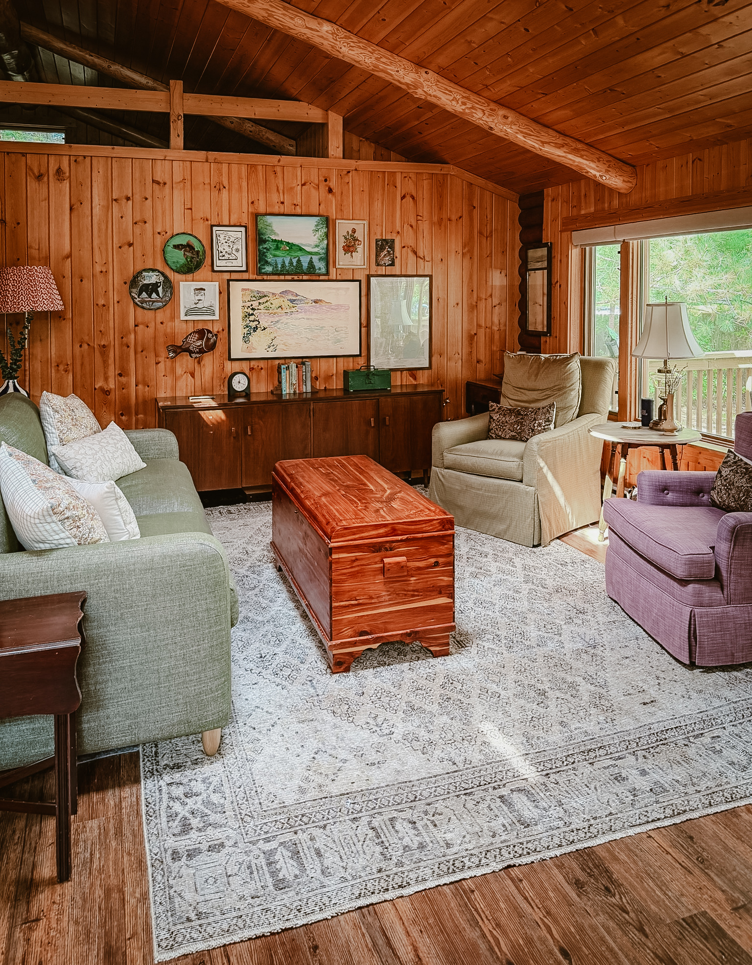 The cabin sitting room with vintage furniture and a gallery wall