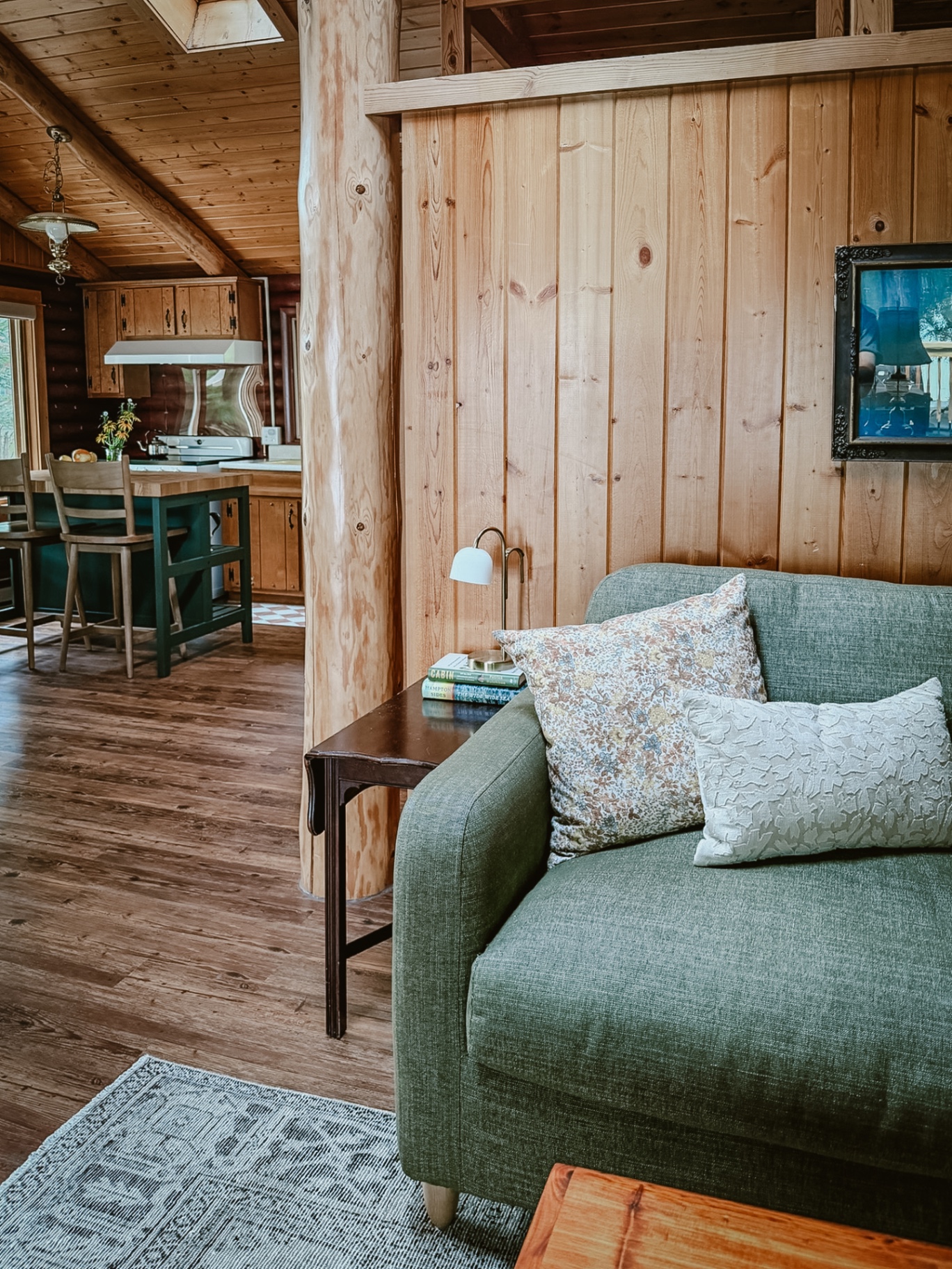 The pine-paneled living room and kitchen with a vaulted wood ceiling