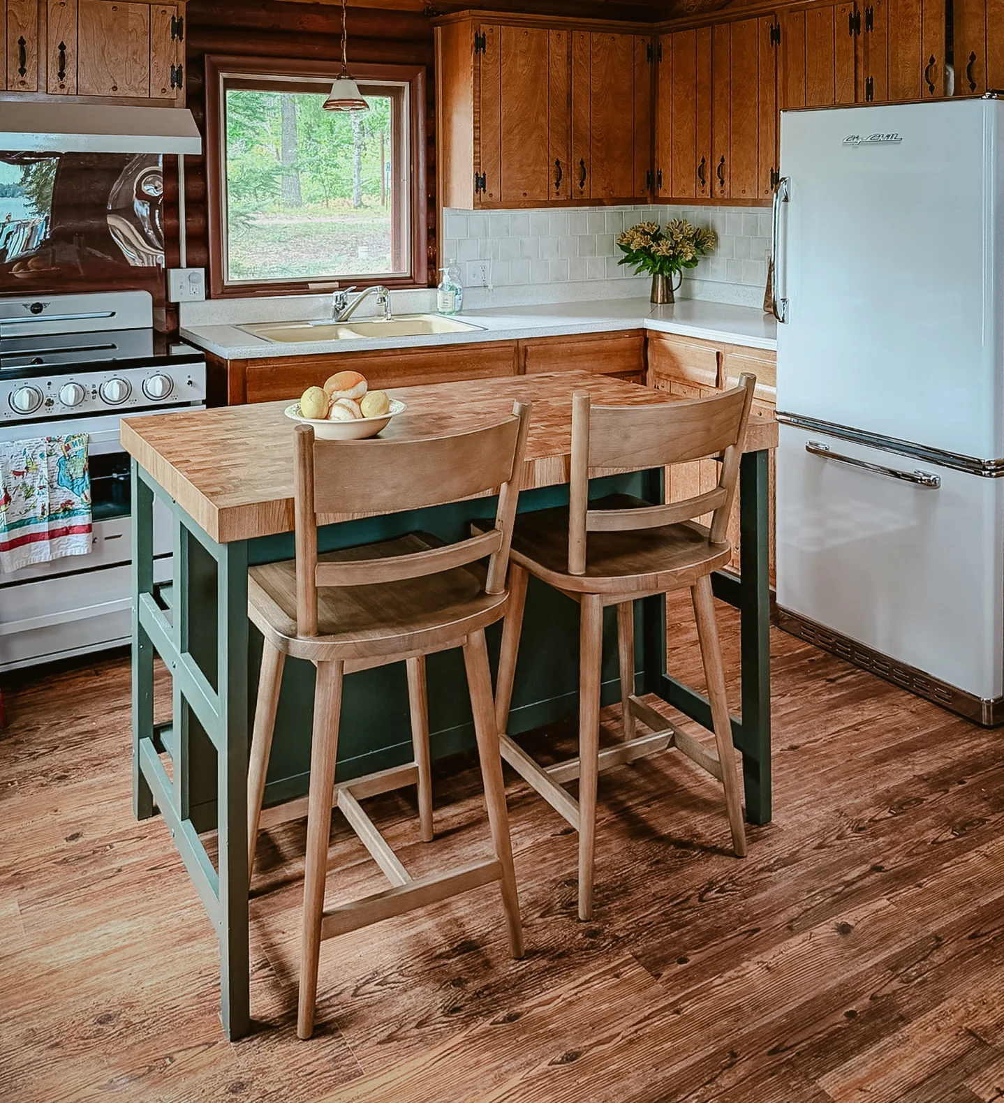 The cabin kitchen with wood cabinets and pine walls