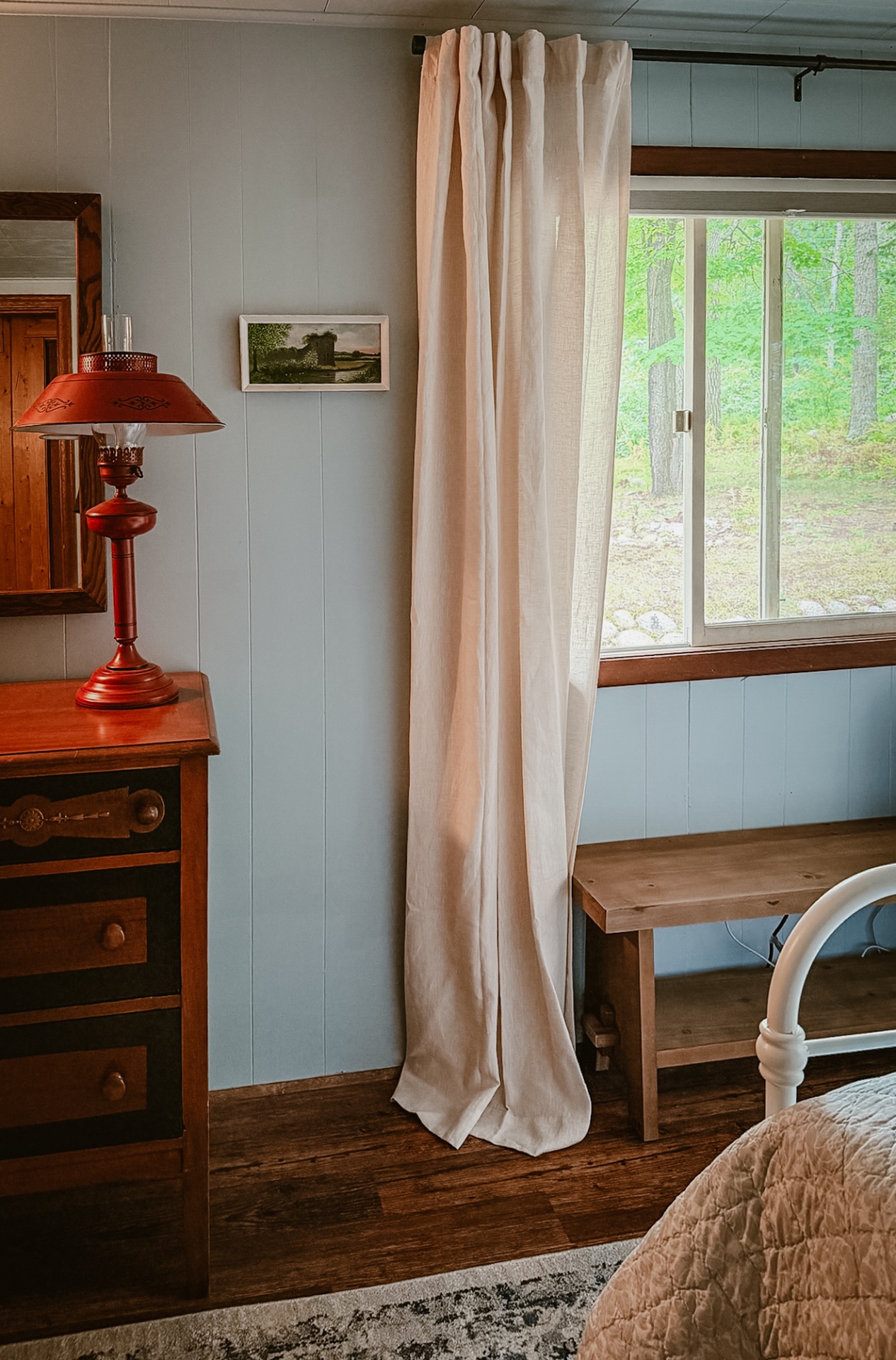 A corner of the second bedroom with a red lamp and a view toward the lake