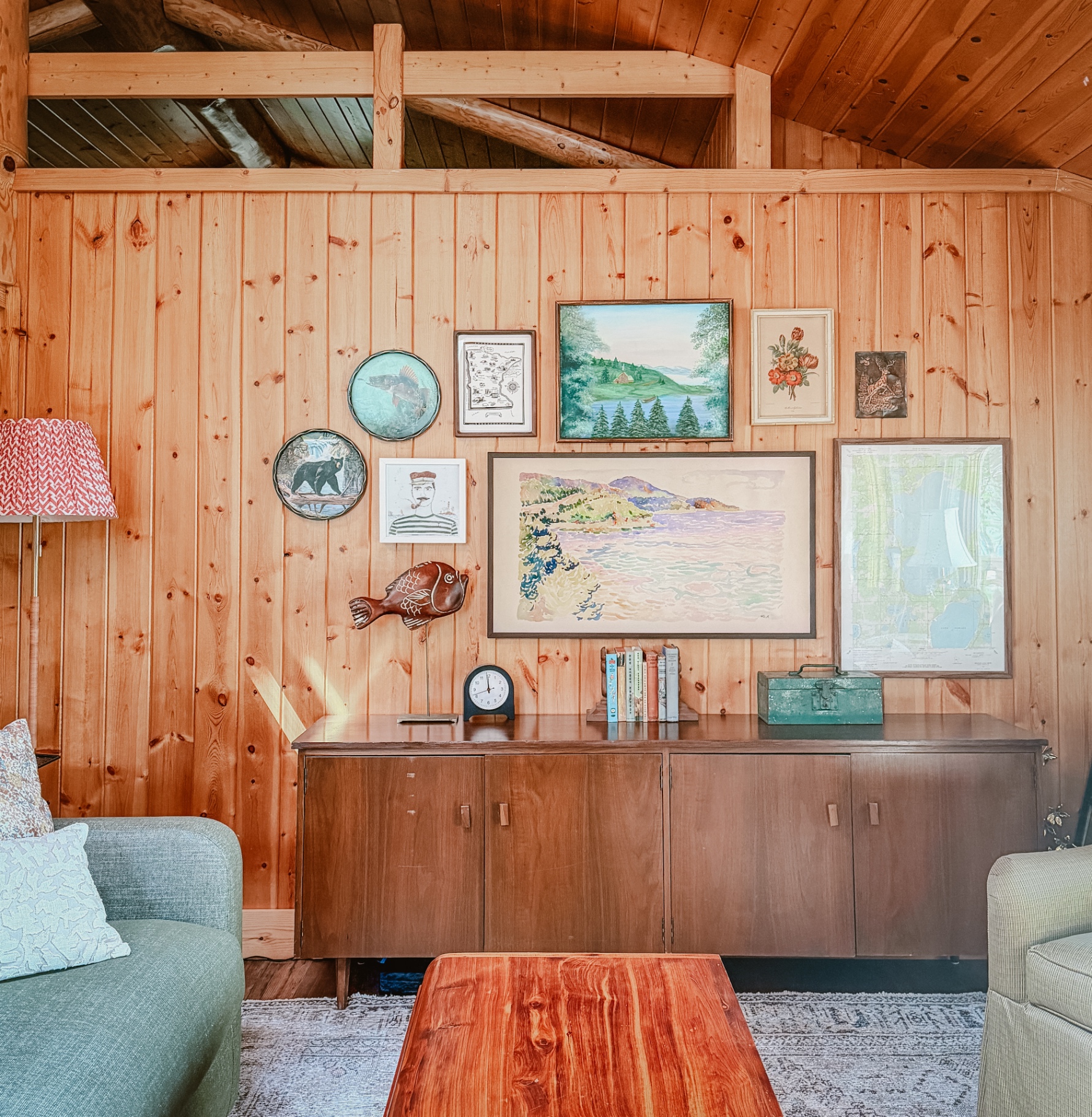 The living room art wall with vintage paintings and mid-century furniture